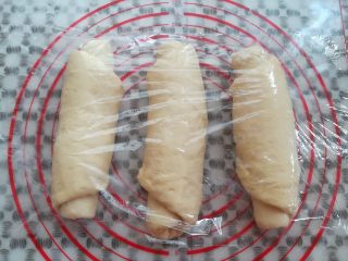 8、经典白吐司,三个面团全部卷好以后盖上保鲜膜再次静置10分钟