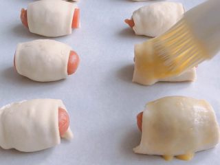 5、香肠飞饼卷,摆入烤盘中，刷上一层蛋液