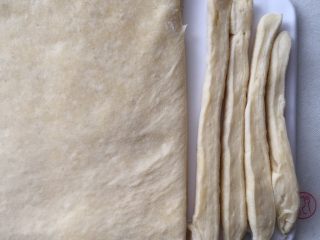 11、酥面包,松弛一会后继续擀成长方形大片,从一边开始切条,立起来擀长