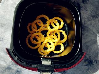 8、空气炸锅版鱿鱼圈, 放入空炸内胆，交错着摆好，表面用刷子稍点少许植物油。压在一起也没关系，空炸是360度受热，不会影响成熟度。