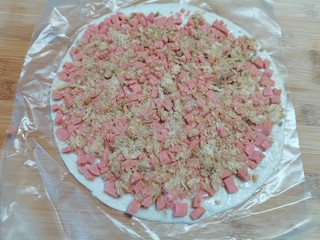 5、手抓饼版火腿肉松酥,把食材压实