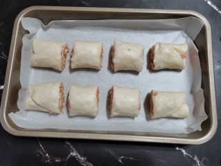 9、手抓饼版火腿肉松酥,烤盘底部放一层油纸，放上火腿肉松卷