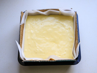 10、古早味蛋糕,模具中提前铺好油纸，油纸要大一些，最好四周要比模具高出很多，把硬纸板放在油纸的外面，倒入拌匀的面糊，模具在台面上震几下，震出大气泡。