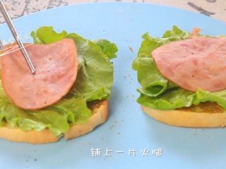 5、牛油果鸡蛋火腿三明治,铺上一片生菜叶。再铺上一片火腿。