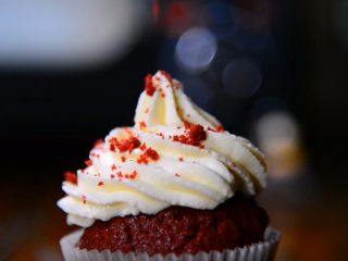 18、二次元美少女教你制作颜值爆表的红丝绒蛋糕,挤好后，慢慢提起裱花嘴。最后，在奶油霜上撒一些蛋糕屑做装饰，红丝绒纸杯蛋糕就全部完成了