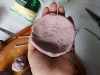 9、奶香拉丝紫薯饼,拿一个小的紫薯面团儿，用手压成饼的形状。