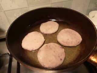 14、奶香拉丝紫薯饼,锅内放少许油，放入饼煎至金黄。