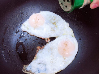 4、鸡蛋汉堡,开盖儿撒上少许黑胡椒粉，将鸡蛋盛出待用。