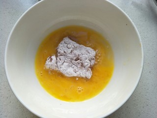 14、炸猪排,再放入鸡蛋液中，反正面沾匀。