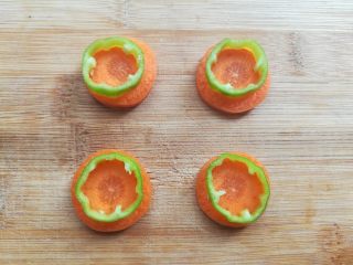 4、百变大眼怪三明治,胡萝卜切成原片，把青椒放在胡萝卜片上用牙签画出需要的胡萝卜轮廓