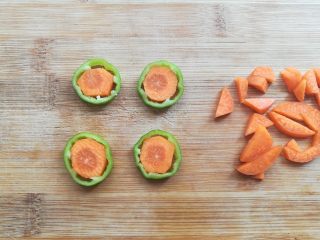 5、百变大眼怪三明治,把胡萝卜用刀切掉轮廓外多余部分后放到青椒圈里