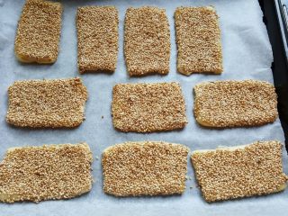 13、芝麻烧饼,13．全部擀好后，上刷全蛋液，粘一层熟的白芝麻，放在铺有烘焙纸的烤盘上。