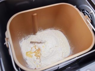 2、芝士榴莲饼,把普通面粉，纯牛奶，盐，玉米油全倒入面包机的和面桶中，启动揉面程序，揉成光滑的面团