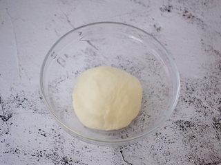 3、芝士榴莲饼,取出面团揉圆放入容器中盖上保鲜膜醒发20分钟