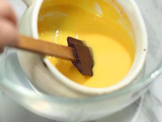 6、蓝莓冰淇淋,小火加热奶锅，并用刮刀不断搅拌，当牛奶蛋黄液变得浓稠，能挂在刮刀上时，立即关火，千万别煮至沸腾，蛋黄会结块。奶锅离火后，隔着冷水继续搅拌蛋黄牛奶液，直到其完全冷却。这一步是为了防止锅的余温继续加热蛋奶液。