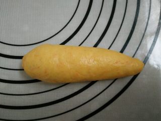 9、胡萝卜小餐包, 9.面团上下两边向中间对折。用手将一端搓成尖角状