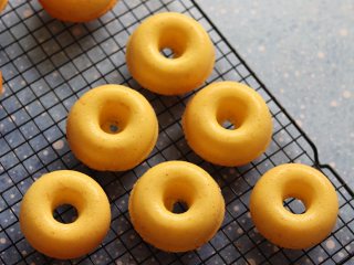 14、橙味甜甜圈蛋糕，在家就可复刻的经典美味,取出稍微晾一下，就可以用牙签划一下，倒扣脱模了。放到晾网上，晾凉。期间可以准备融化巧克力，蔓越莓干切碎。