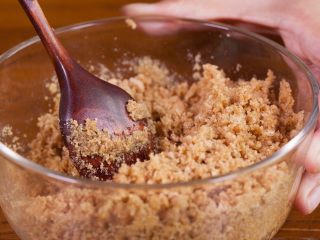 4、【免烤箱蛋糕】零失败芒果慕斯蛋糕,将消化饼干和黄油充分混合拌匀。