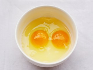 3、超好吃的蛋烤吐司块,鸡蛋磕入碗中。