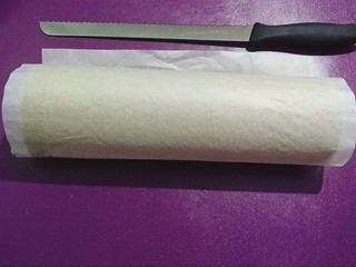 34、黑芝麻蛋糕卷,把蛋糕卷整个卷起来，用油纸全部包好，放冰箱冷藏一个小时以上；