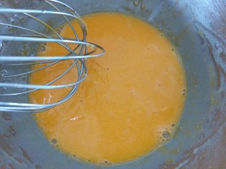 2、咸蛋黄肉松盒子蛋糕,先把油放进蛋黄内，用手动打蛋器搅拌均匀。再加入纯净水搅拌均匀。