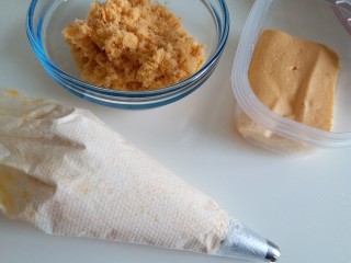 11、咸蛋黄肉松盒子蛋糕,咸蛋黄奶油装进裱花袋里，肉松准备好，蛋糕切成小块，可以根据自己的盒子的大小去切，我用的小盒子，如果用大盒子，奶油和肉松的量都要增加哦。