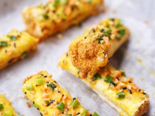 14、肉松芝士吐司卷,放入铺好油纸的烤盘，推入预热好的烤箱，180度烤5分钟。