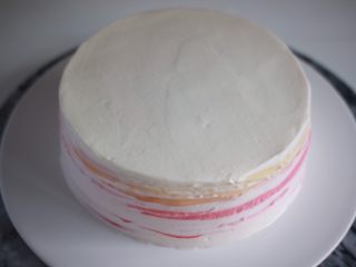 19、红丝绒渐变千层蛋糕,按照这样的顺序抹完所有的千层皮。剩下的淡奶油我抹了表面和侧面。侧面不完全用淡奶油盖住,呈现自然的渐变色纹路