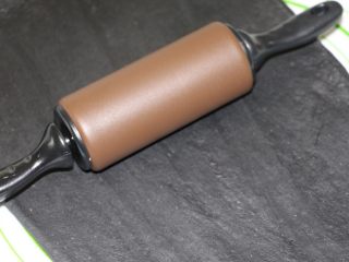 11、飘香竹炭椰蓉面包,取出面团用擀面杖排一下气