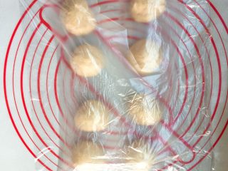 6、超级松软的    炼乳小面包,排气的面团均匀的分成8份，包上保鲜膜松弛20分钟。