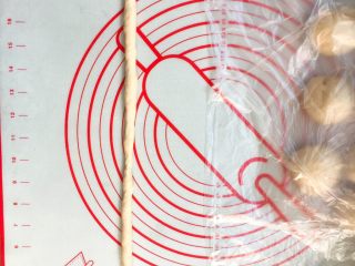 7、超级松软的    炼乳小面包,取一个松弛好的面团，揉面排气，搓成长条状。