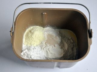 1、黄油椰蓉吐司条,把液体材料放入面包桶中，面粉铺在上面，对角分别上放上盐、糖、奶粉，在面粉中间挖一个小坑，放上酵母，启动面包机揉面程序10分钟。