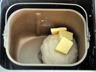 2、黄油椰蓉吐司条, 揉至面筋扩展，表面光滑，加入软化的黄油。