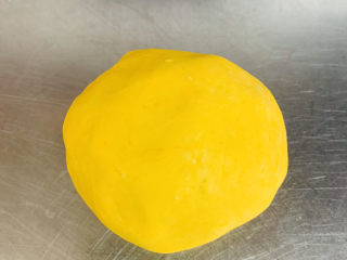 7、南瓜芝麻球,搅拌好的南瓜絮倒入案板上揉搓成光滑的面团。