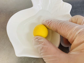 11、南瓜芝麻球,在水碗里表面少少的粘上一点水，这样做让芝麻更好地贴合在南瓜球上。