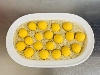 12、南瓜芝麻球,粘好水的南瓜球放入芝麻碗中沾满芝麻