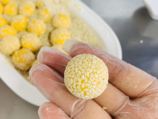 13、南瓜芝麻球,双手在对揉一下，上芝麻更紧实的贴合在南瓜球上