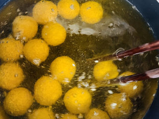 16、南瓜芝麻球,刚刚下入的南瓜球，会沉在锅底，用筷子轻轻拨动，防止粘连。