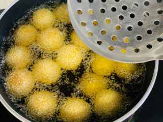 18、南瓜芝麻球,看到南瓜球漂浮起来，用笊篱轻轻按压南瓜球像油锅底部。
