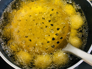 19、南瓜芝麻球,要轻轻按压浮起的南瓜球，抬起笊篱，这样反复操作。