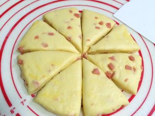 10、芝士香肠司康,用刮板把擀开的面片切成八份。