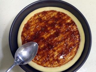 13、培根口蘑田园披萨,在饼底上抹好披萨酱。