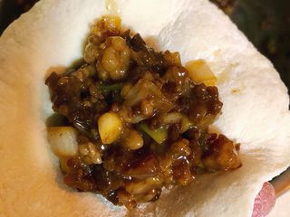 13、酱肉大包子,擀好的包子皮中放入50克左右的酱肉馅。
