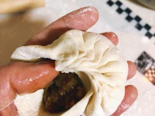 14、酱肉大包子,右手大拇指和食指从皮子的一侧向前折皱，大概折15次以上，折时左手大拇指把馅抵住，直到折完包子皮。