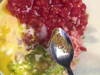 5、煎饼,放入火腿丁，葱花，西红柿，再打入两个鸡蛋，加盐，五香粉