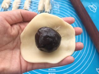 29、全面详细讲解～蛋黄酥,把之前裹好蛋黄的豆沙放入面皮中间。