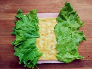 8、快手棒棒糖三明治,再将切得大小合适的鸡蛋饼和生菜叶放在上面。生菜的多少可根据个人喜好酌情增减