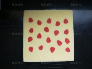 13、草莓彩绘蛋糕卷,然后反过来放晾架上,撕掉油布。停留一分钟,让蛋糕稍微冷却一下。草莓图案和蛋糕是平面一体的。