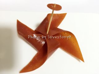 12、风车果丹皮,再用做风车的方法挨个把果丹皮小角穿入牙签,最后插入中间固定。