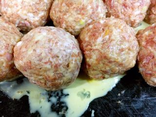 10、做年货 家宴特色秘制龙眼丸子（31个步骤图文详细解释）,把第15步调好的鸡蛋淀粉糊淋在所有的龙眼丸子上。